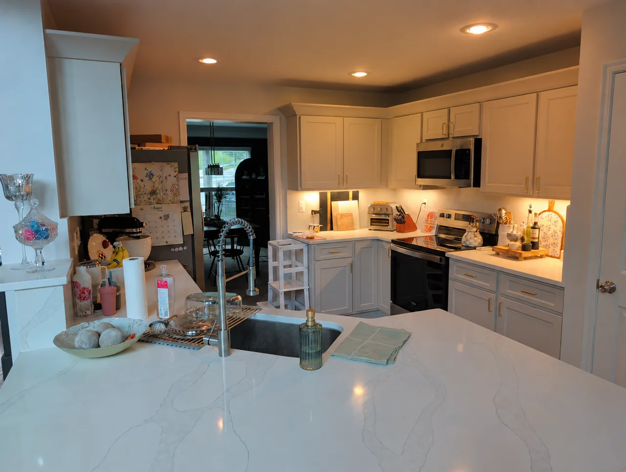 Refaced white kitchen cabinets with shaker doors and gold hardware